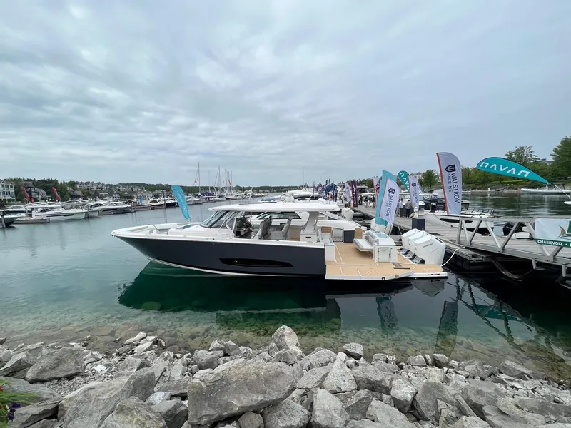 Slide: The Image of 2026 Regal 50 SAV yacht docked at a marina under cloudy skies. - 1