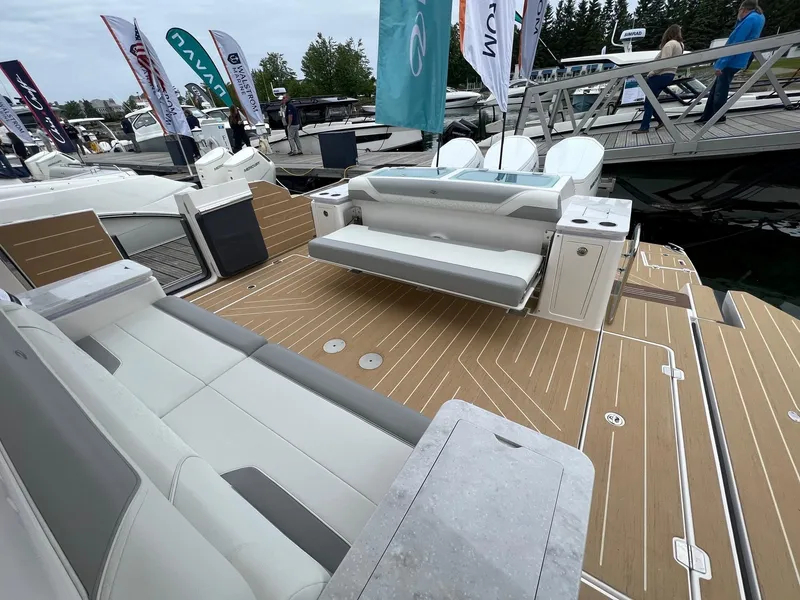 Slide: The Image of 2026 Regal 50 SAV luxury boat deck with seating and modern design at a marina. - 5