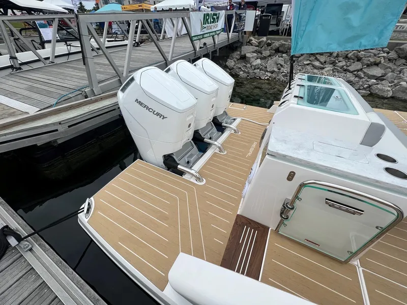 Slide: The Image of 2026 Regal 50 SAV boat with triple Mercury outboard engines docked at a marina. - 9
