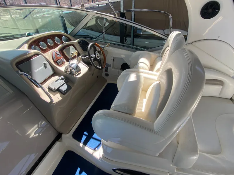 Slide: The Image of 2003 Sea Ray 340 Sundancer cockpit with white leather seats and wooden dashboard. - 13