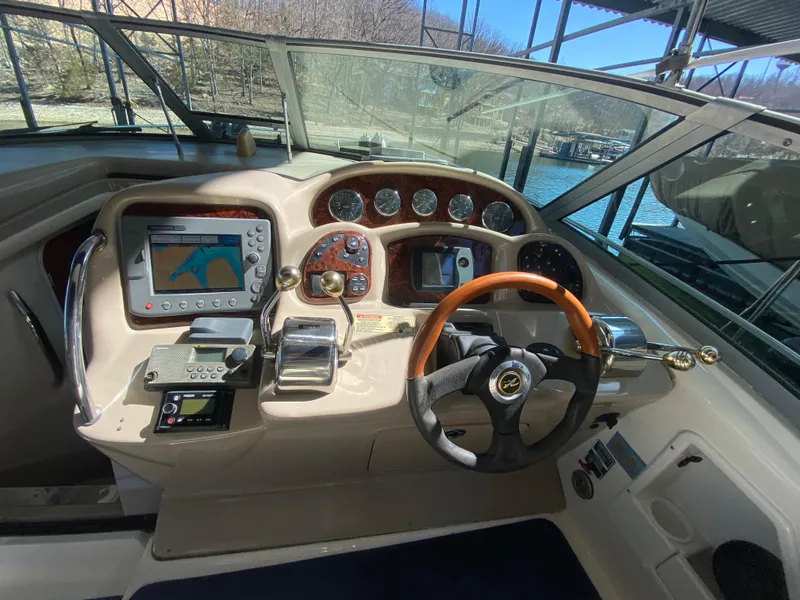 Slide: The Image of 2003 Sea Ray 340 Sundancer helm with navigation system and wooden steering wheel. - 18