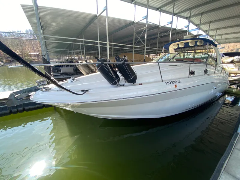 Slide: The Image of 2003 Sea Ray 340 Sundancer docked in a covered marina, side view. - 2