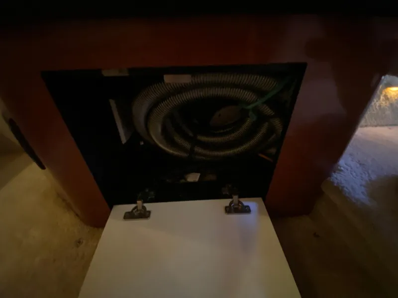 Slide: The Image of Open cabinet with coiled hoses inside a 2003 Sea Ray 340 Sundancer boat. - 29