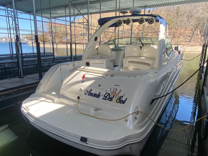 Slide: The Image of 2003 Sea Ray 340 Sundancer docked in a marina, featuring a spacious deck and seating area. - 3