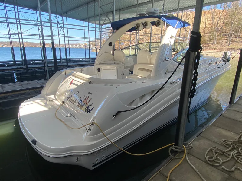 Slide: The Image of 2003 Sea Ray 340 Sundancer docked in a marina, featuring sleek white design. - 4