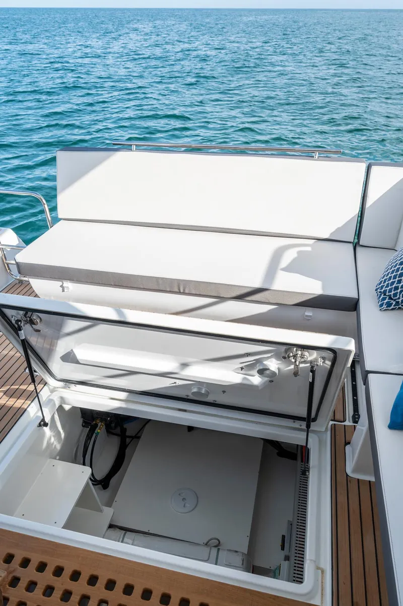 Slide: The Image of 2026 Beneteau Antares 11 OB boat with open storage compartment, docked on calm water. - 15
