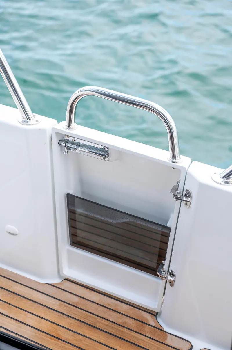 Slide: The Image of 2026 Beneteau Antares 11 OB boat deck with wooden flooring and stainless steel railing. - 16
