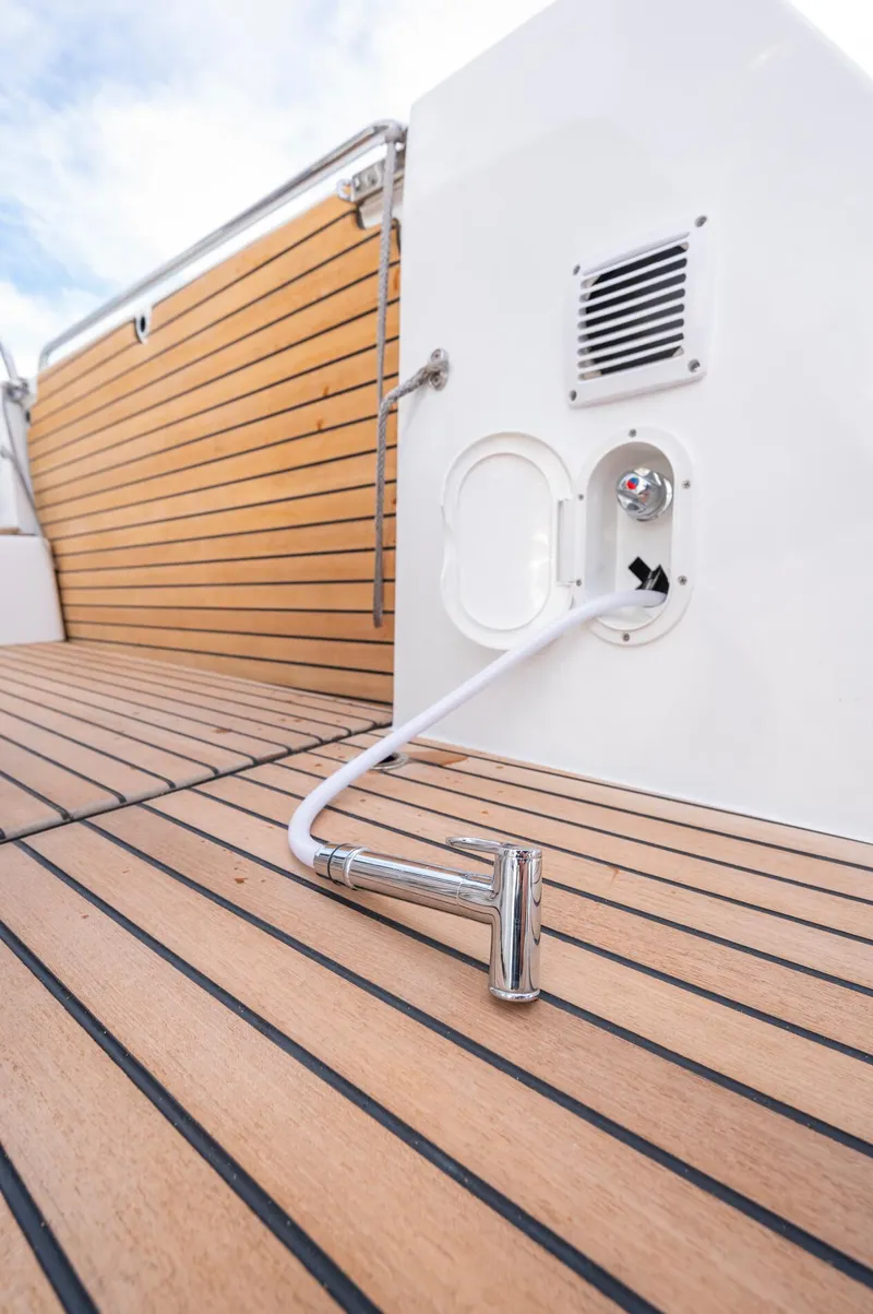 Slide: The Image of 2026 Beneteau Antares 11 OB deck with hose and wood finish. - 17