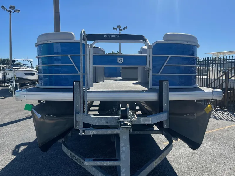 Slide: The Image of 2022 Godfrey SWEETWATER 2286 SFL pontoon boat on trailer, blue exterior, parked outdoors. - 3