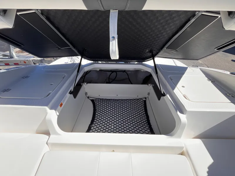 Slide: The Image of 2025 Chaparral 21 SSi OB boat storage compartment with open hatch and netting. - 17