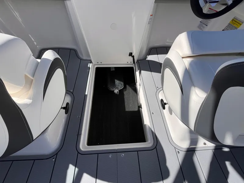 Slide: The Image of 2025 Chaparral 21 SSi OB boat interior with open storage compartment between seats. - 18