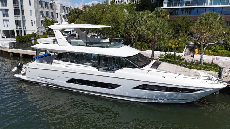 Slide: The Image of Luxury 2018 Prestige 680 yacht docked by waterfront buildings and lush greenery. - 0