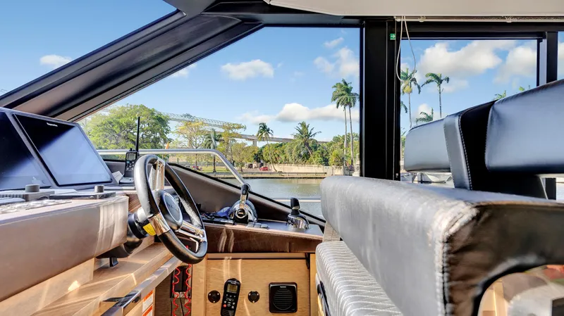 Slide: The Image of Interior view of 2018 Prestige 680 yacht cockpit with scenic waterway backdrop. - 14