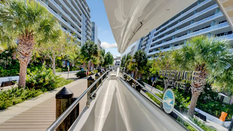 Slide: The Image of Luxurious 2018 Prestige 680 yacht docked near modern waterfront apartments and palm trees. - 20