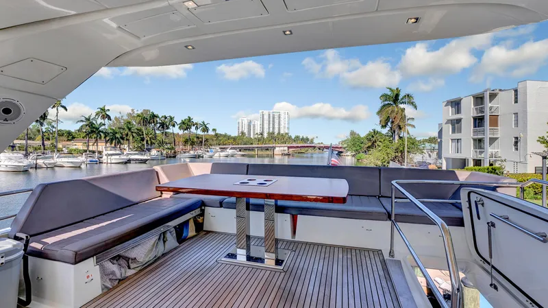 Slide: The Image of Luxurious 2018 Prestige 680 yacht deck with seating, table, and scenic marina view. - 26