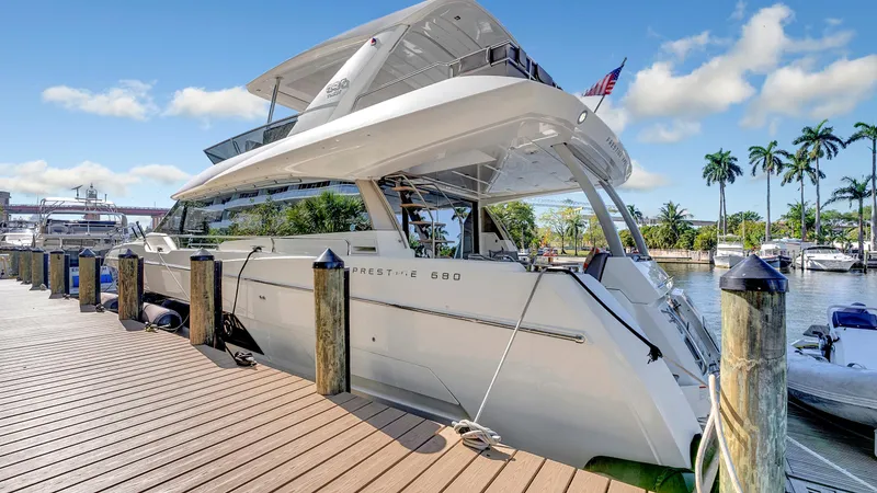 Slide: The Image of Luxury 2018 Prestige 680 yacht docked at marina under clear blue sky. - 35