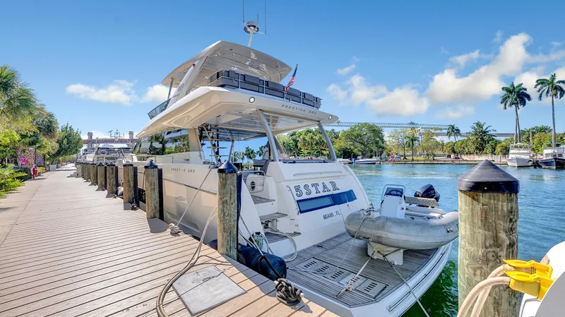 Slide: The Image of Luxury 2018 Prestige 680 yacht docked at a sunny marina with palm trees. - 36