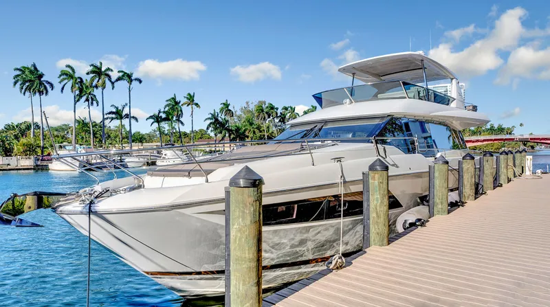 Slide: The Image of Luxury 2018 Prestige 680 yacht docked by palm trees and blue water. - 40