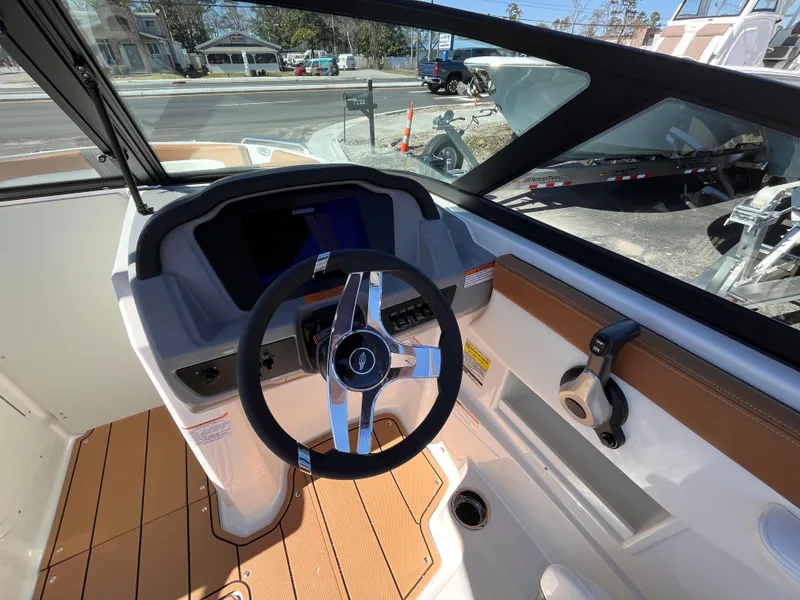 Slide: The Image of 2025 Chaparral 23 SSi OB boat cockpit with steering wheel and dashboard controls. - 10