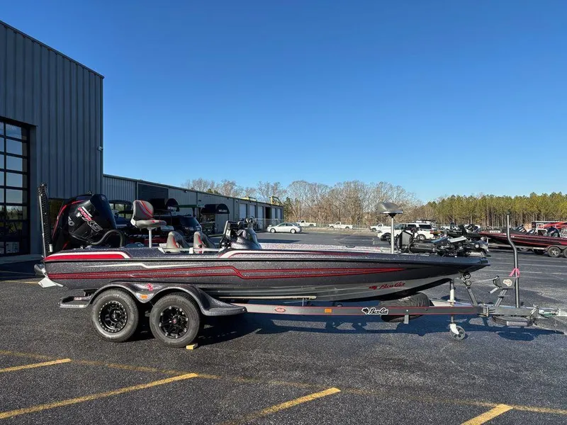 The Image of 2022 Bass Cat Cougar FTD boat on trailer in parking lot, clear blue sky. - 1