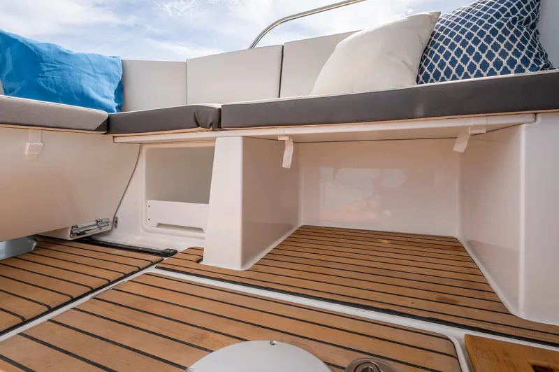 Slide: The Image of 2026 Beneteau Antares 11 OB boat interior with cushioned seating and wooden flooring. - 14