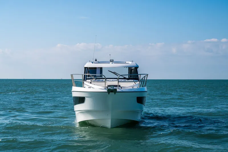 Slide: The Image of 2026 Beneteau Antares 11 OB cruising on open sea under clear blue sky. - 9