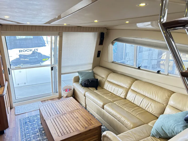 Slide: The Image of Luxurious interior of 2004 Cruisers Yachts 5000 Sedan Sport with leather seating and wooden table. - 13