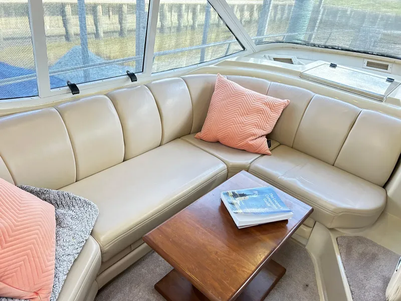 Slide: The Image of Luxurious 2004 Cruisers Yachts 5000 Sedan Sport interior with beige seating and wooden table. - 19