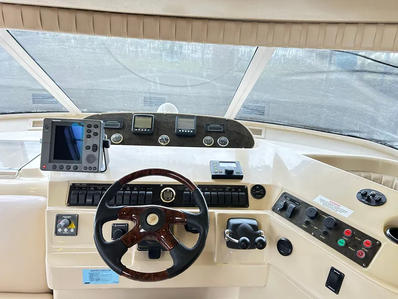 Slide: The Image of 2004 Cruisers Yachts 5000 Sedan Sport helm with steering wheel and navigation controls. - 22