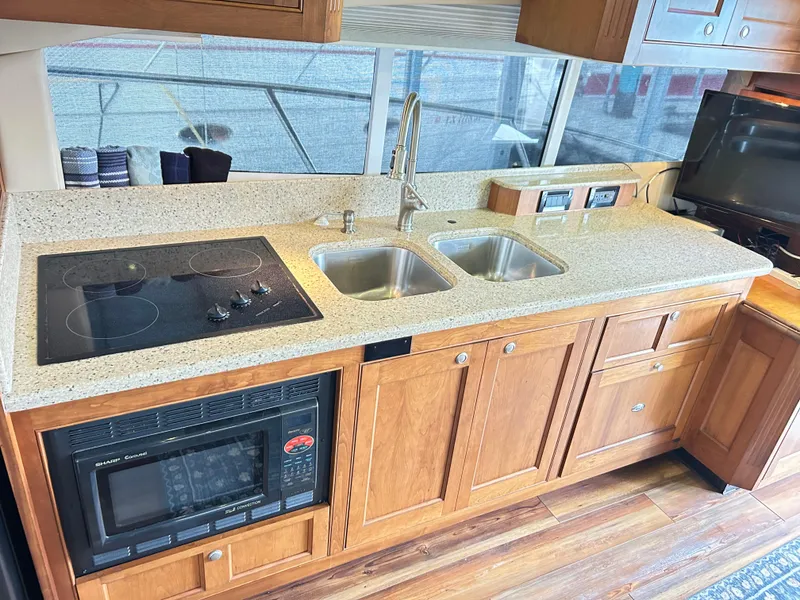 Slide: The Image of 2004 Cruisers Yachts 5000 Sedan Sport kitchen with stove, microwave, and dual sinks. - 25