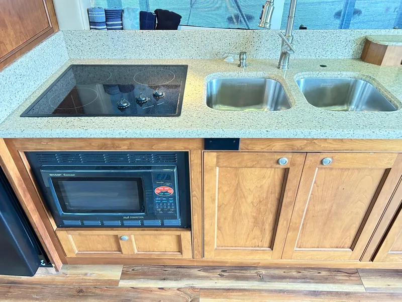 Slide: The Image of 2004 Cruisers Yachts 5000 Sedan Sport kitchen with stove, microwave, and double sink. - 26