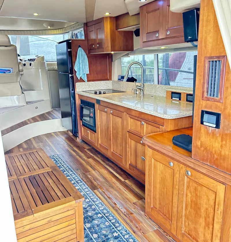 Slide: The Image of 2004 Cruisers Yachts 5000 Sedan Sport interior with wood cabinetry and modern kitchen amenities. - 33