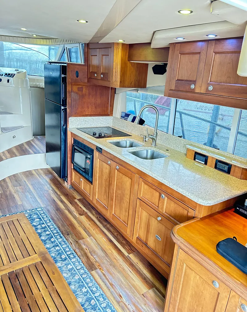 Slide: The Image of Luxurious 2004 Cruisers Yachts 5000 Sedan Sport kitchen with wood cabinetry and modern appliances. - 39