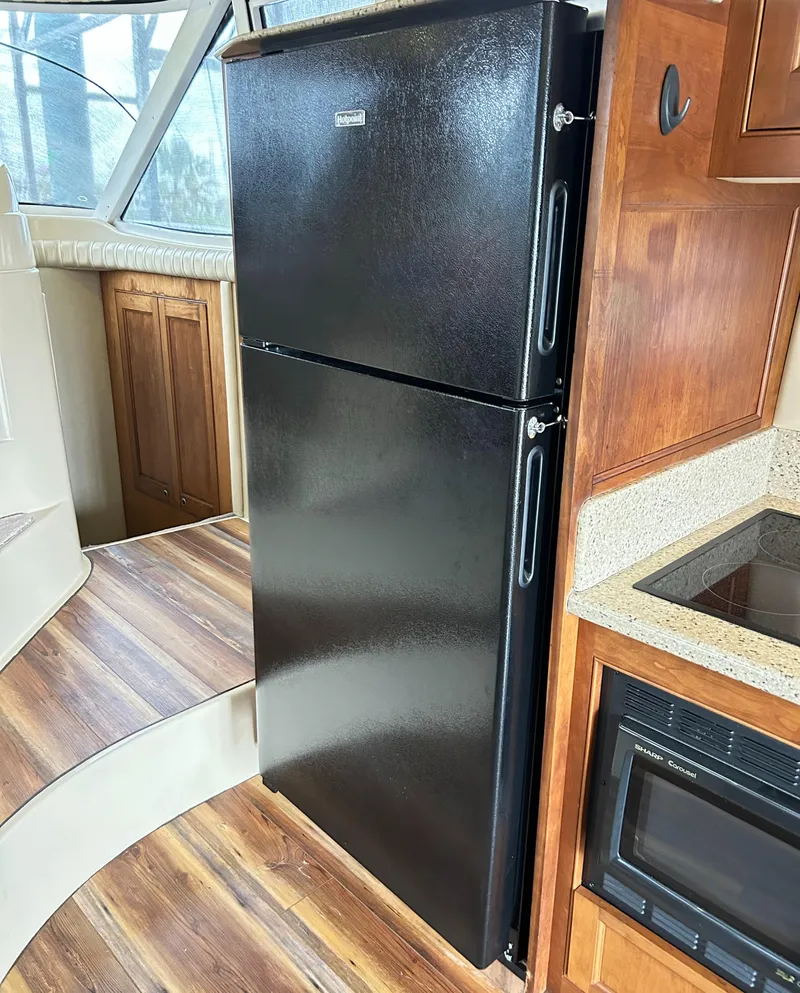 Slide: The Image of Black refrigerator in 2004 Cruisers Yachts 5000 Sedan Sport kitchen area. - 40