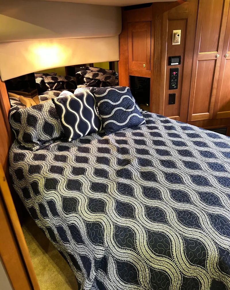 Slide: The Image of Luxurious bedroom in 2004 Cruisers Yachts 5000 Sedan Sport with patterned bedding. - 45