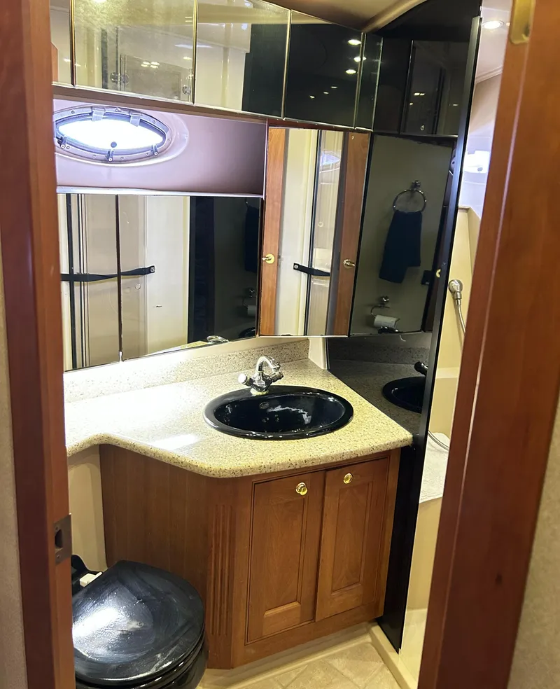 Slide: The Image of 2004 Cruisers Yachts 5000 Sedan Sport bathroom with wood cabinetry and black sink. - 47