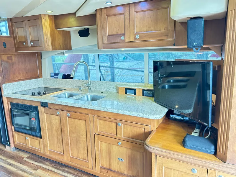 Slide: The Image of 2004 Cruisers Yachts 5000 Sedan Sport kitchen with wood cabinets and modern appliances. - 17