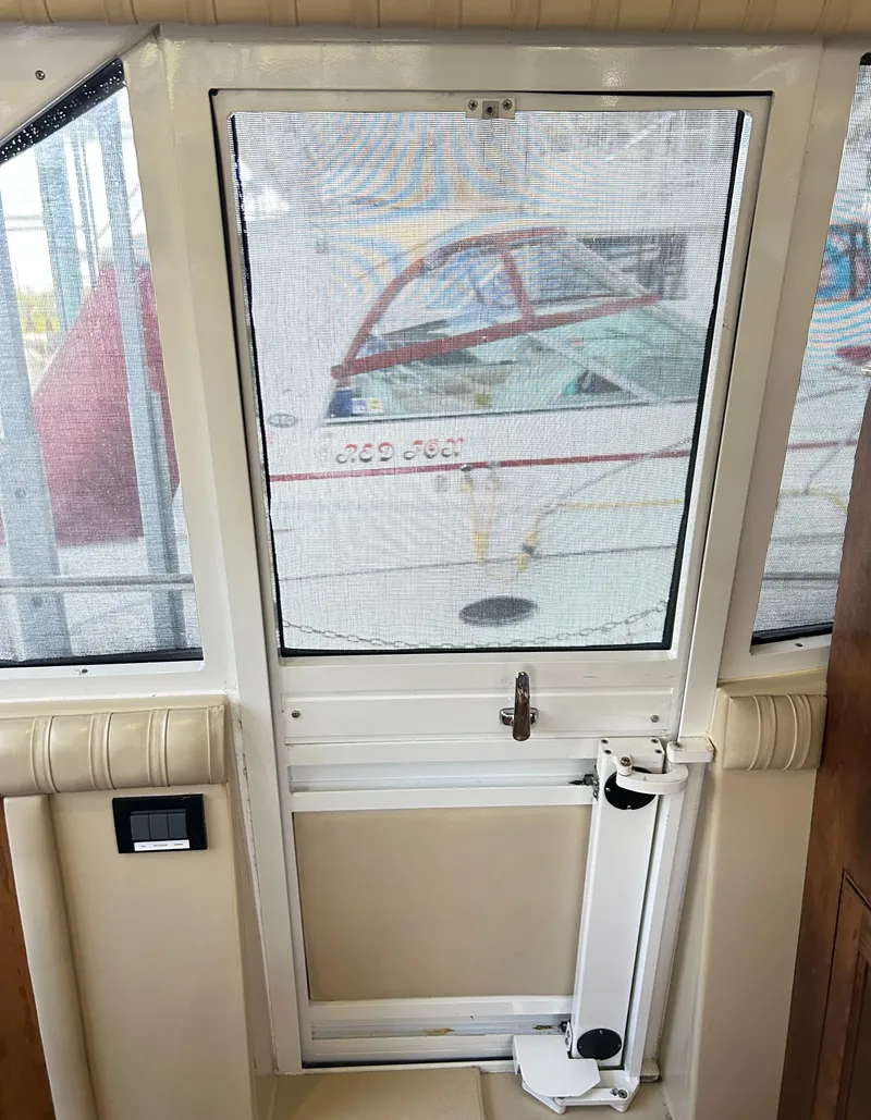 Slide: The Image of 2004 Cruisers Yachts 5000 Sedan Sport interior door with mesh screen and exterior view. - 30
