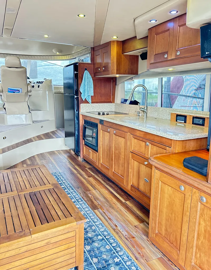 Slide: The Image of 2004 Cruisers Yachts 5000 Sedan Sport interior with wood cabinetry and modern kitchen amenities. - 34
