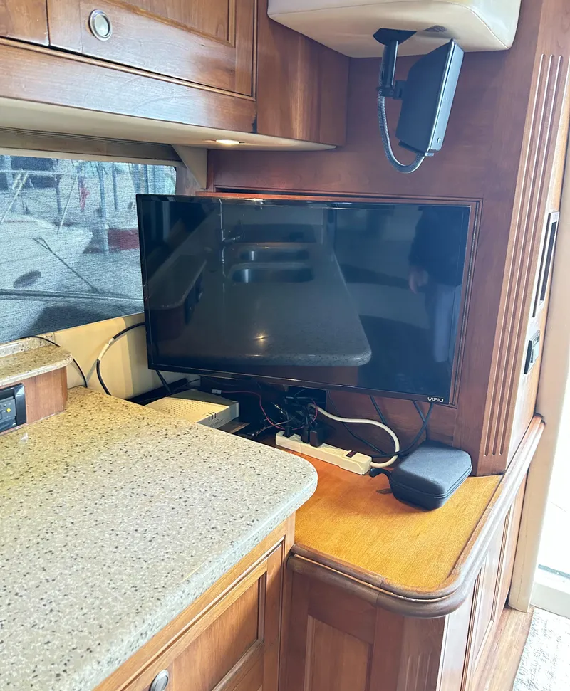 Slide: The Image of 2004 Cruisers Yachts 5000 Sedan Sport interior with TV and wooden cabinetry. - 37