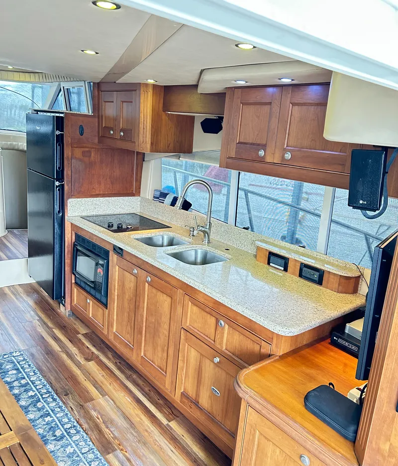 Slide: The Image of 2004 Cruisers Yachts 5000 Sedan Sport kitchen with wood cabinets and modern appliances. - 38