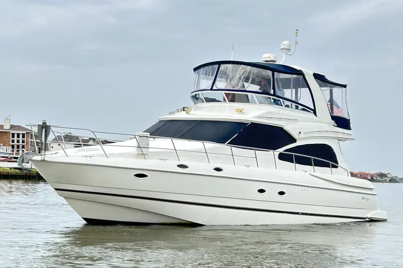 Slide: The Image of 2004 Cruisers Yachts 5000 Sedan Sport on calm water, showcasing sleek design and luxury features. - 4