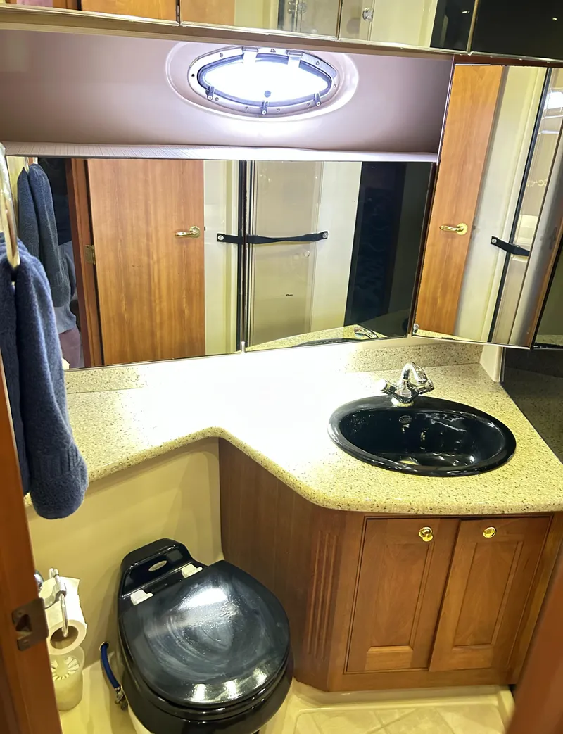 Slide: The Image of 2004 Cruisers Yachts 5000 Sedan Sport bathroom with sink, toilet, and storage cabinets. - 48