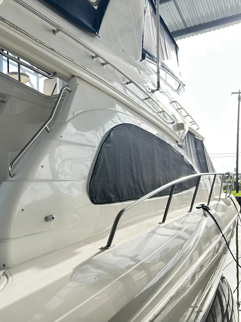 Slide: The Image of 2004 Cruisers Yachts 5000 Sedan Sport, side view, docked under shelter. - 9