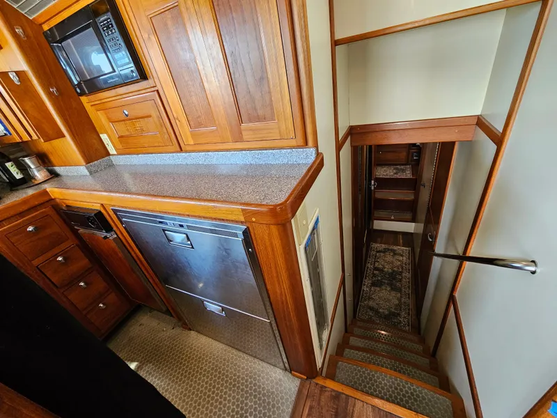 Slide: The Image of Interior of 2002 Nordhavn Trawler with wooden cabinetry and stairs leading below deck. - 12