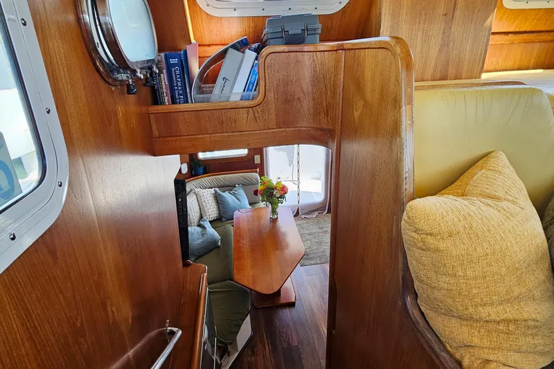 Slide: The Image of Interior of a 2002 Nordhavn Trawler with wooden furnishings and cozy seating area. - 15