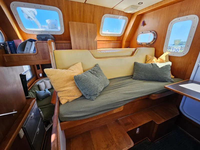 Slide: The Image of Cozy interior of a 2002 Nordhavn Trawler with cushioned seating and wooden accents. - 16