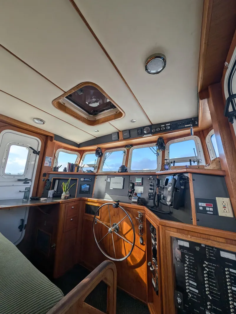 Slide: The Image of 2002 Nordhavn Trawler helm with wooden interior, navigation equipment, and panoramic windows. - 21