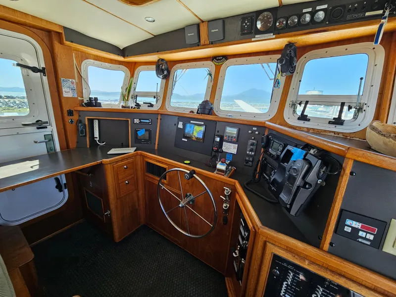 Slide: The Image of 2002 Nordhavn Trawler helm with wooden interior and navigation equipment. - 23