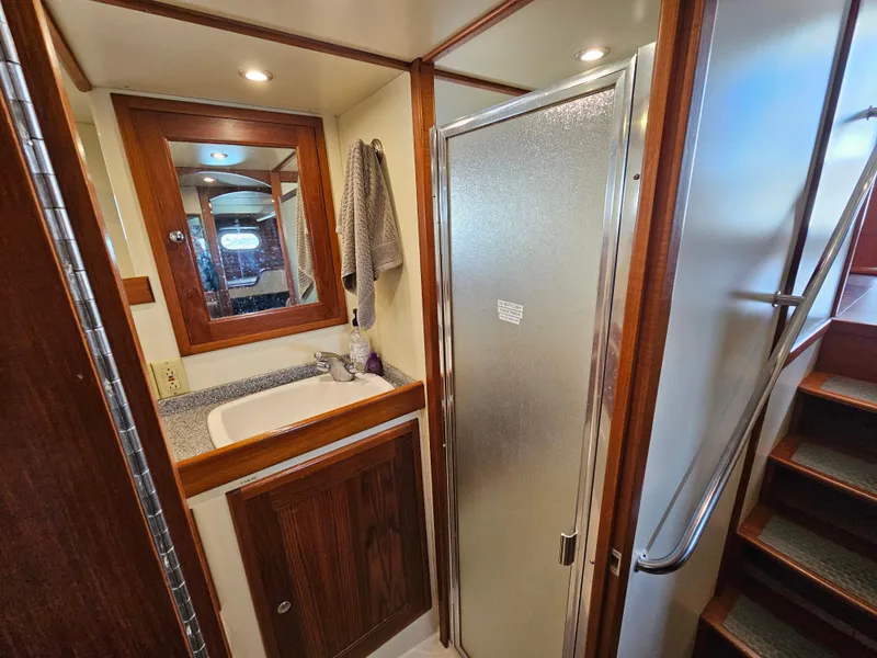 Slide: The Image of 2002 Nordhavn Trawler bathroom with wooden cabinetry, sink, and shower. - 28